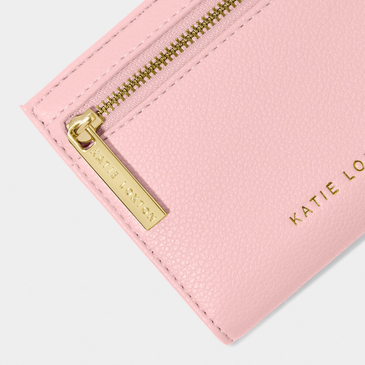 Close up of the Katie Loxton Jayde purse. There is particular focus on the zip, which has Katie Loxton imprinted on it, as well as Katie Loxton in gold lettering at the base of the purse.