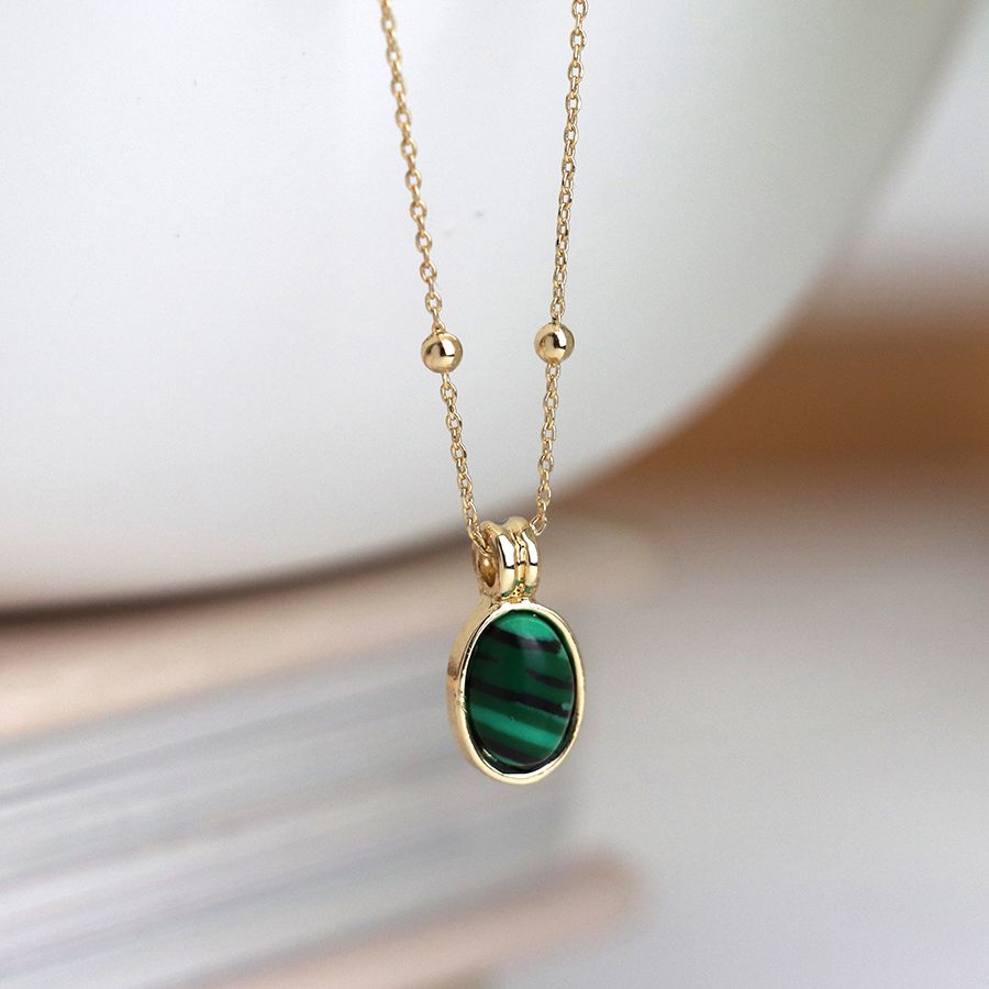 Golden necklace with small oval green mix stone