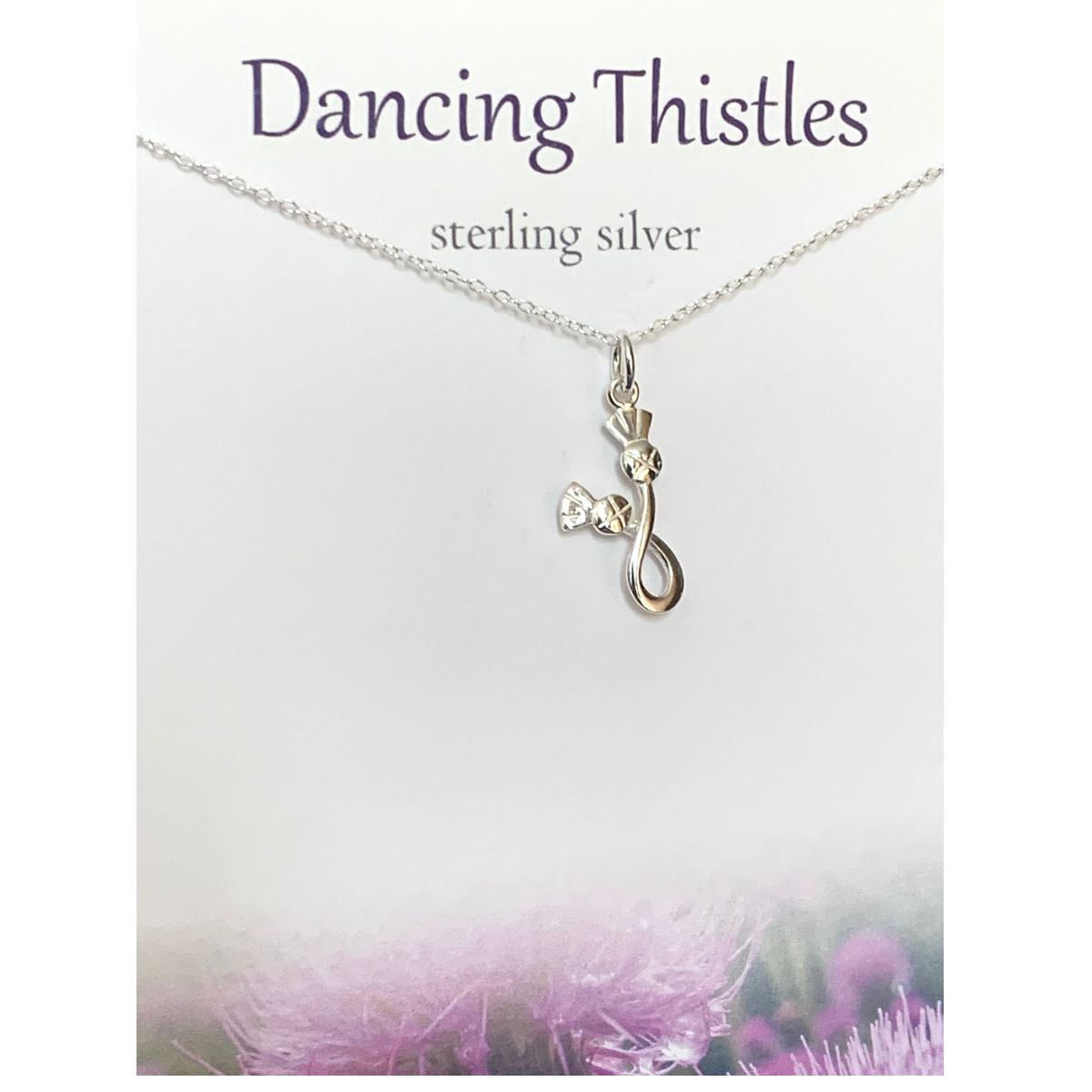 Card saying 'Dancing Thistles, Sterling Silver' featuring a sterling silver necklace with two entwined thistles as a pendant.