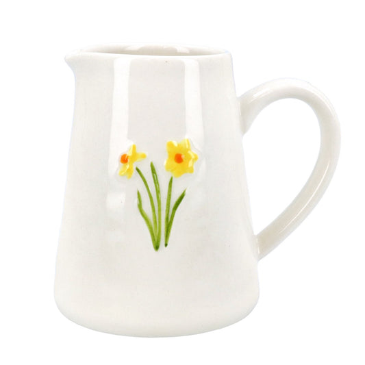 white stoneware jug featuring two yellow daffodils with orange centres, green stems and leaves