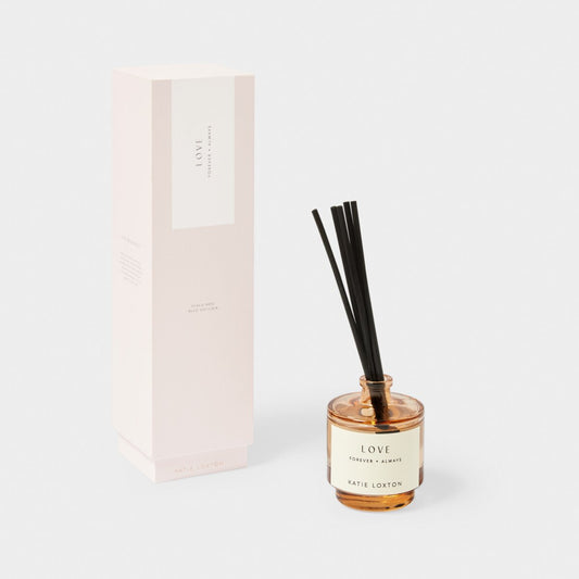 reed diffuser in an amber glass bottle with 'love' and blush pink box