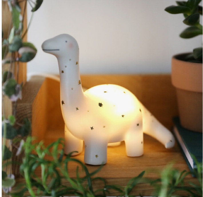 dinosaur nightlight with glowing light surrounded by green plants