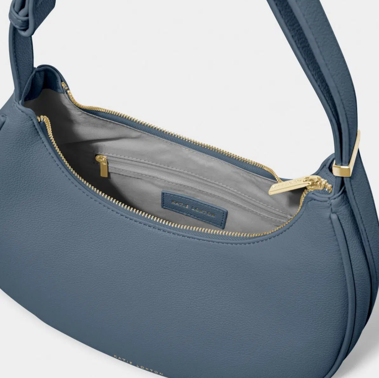 inside shot of navy scoop handbag showing grey lining and interior side pocket with gold zip
