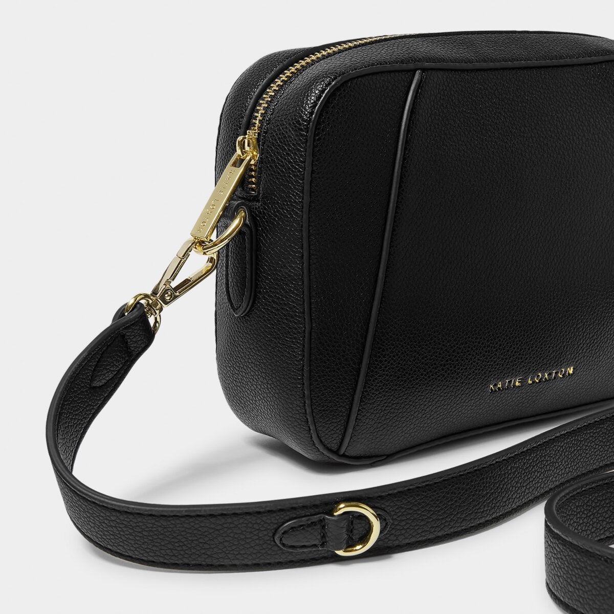 close up of black crossbody handbag focussing on gold zipper and bag hardware
