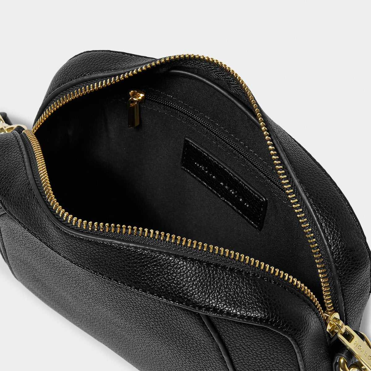 interior shot of black crossover handbag focussing on internal zipped pocket