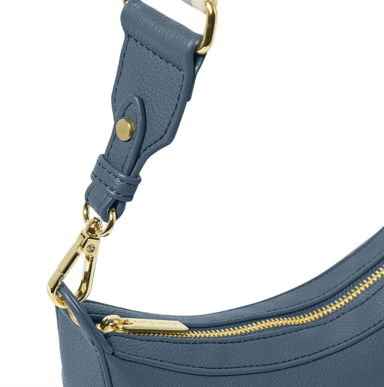 close up of Katie Loxton marni scoop handbag in navy. It shows the bag hardware; a gold zip and strap clips.