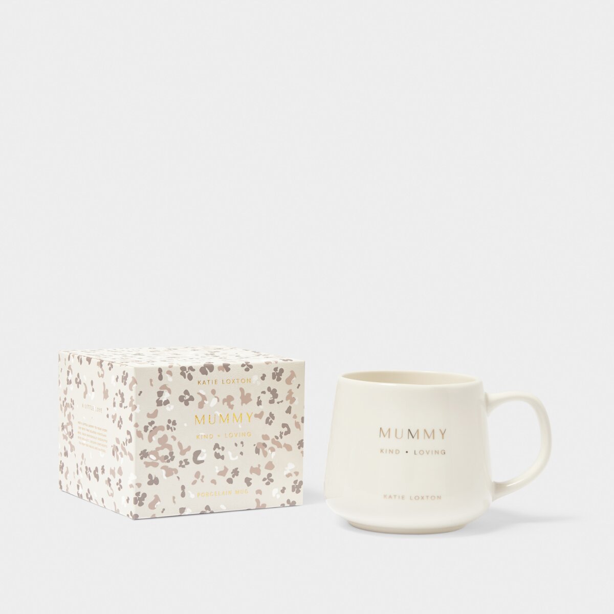 White mug with 'mummy' 'kind' and 'loving' stamped in gold on the front sitting next to a floral gift box