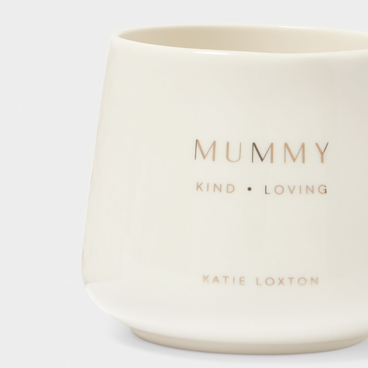 Close up of White mug with 'mummy' 'kind' and 'loving' stamped in gold on the front. 