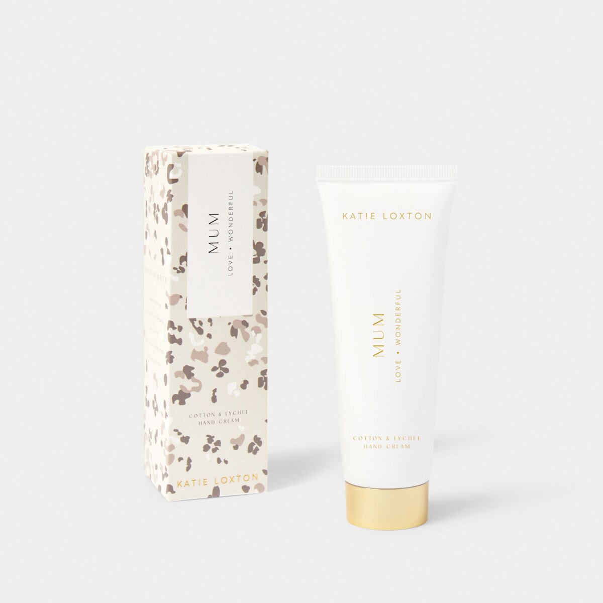 A Tube of 'Mum' handcream sitting next to its blossom floral decorated box.