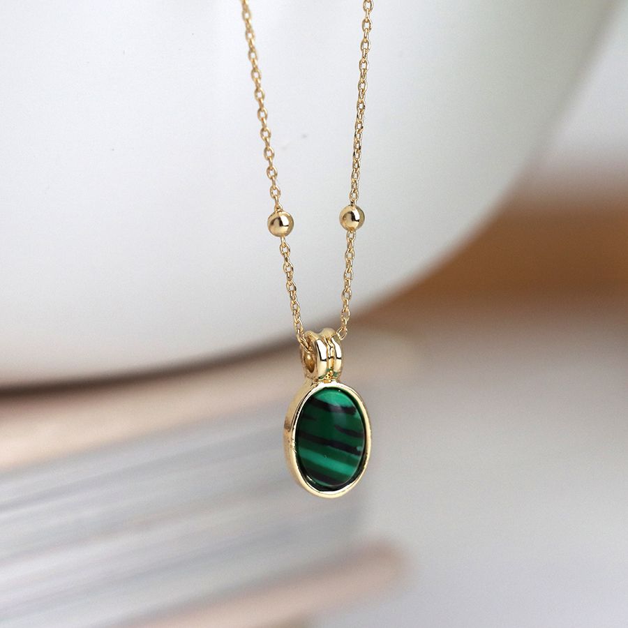 Golden necklace with small oval green mix stone