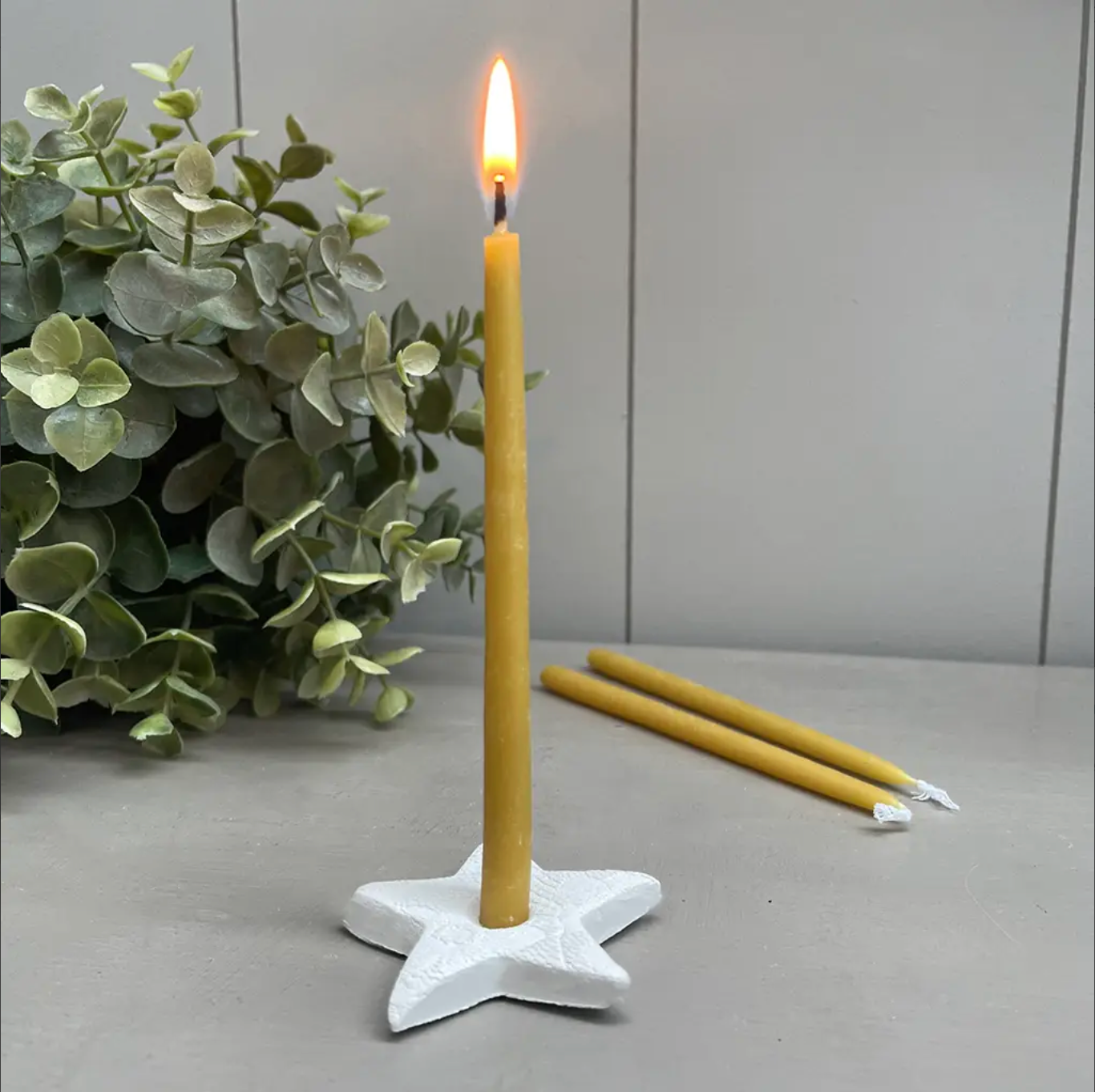 beeswax candle in star shaped ceramic holder